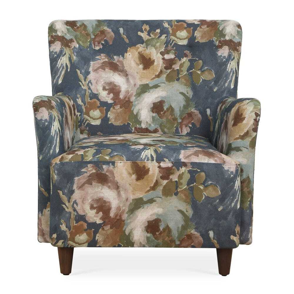 Floral armchair with a blue background, large muted pink and cream flowers, and wooden legs