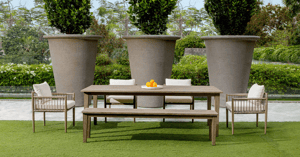 outdoor dining table with planters in background