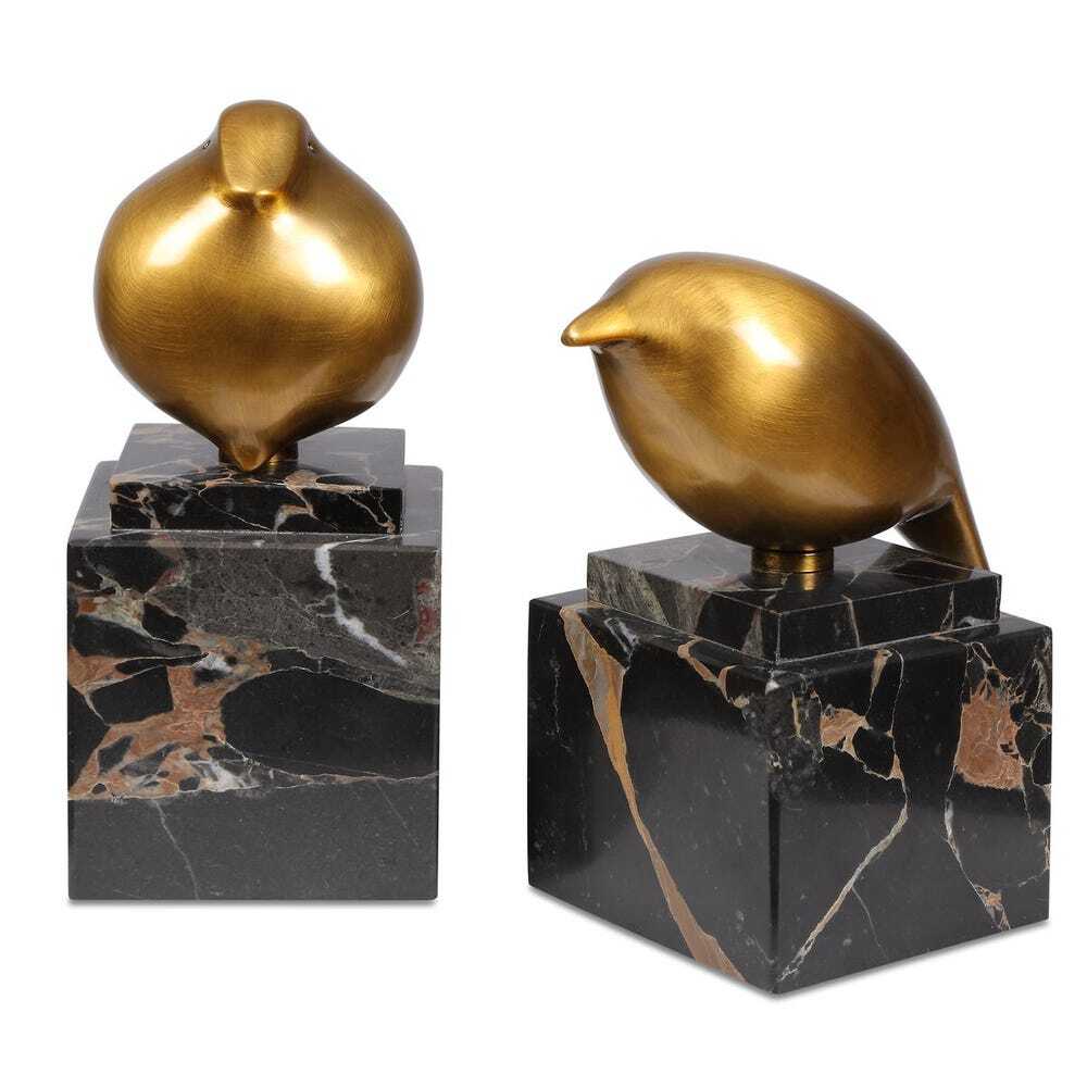 Two gold bird sculptures on black marble bases