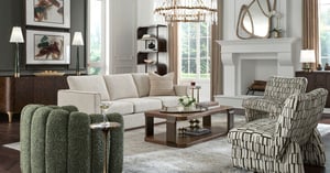 A living room featuring neutral-toned sofa and patterned armchairs around a wooden coffee table