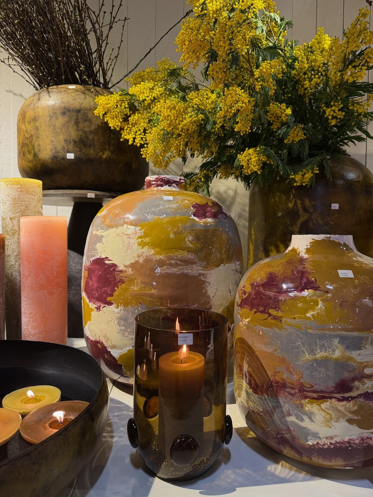  &nbsp;Decorative vases, candles, and yellow flowers arranged in a warm-toned home decor display&nbsp;
