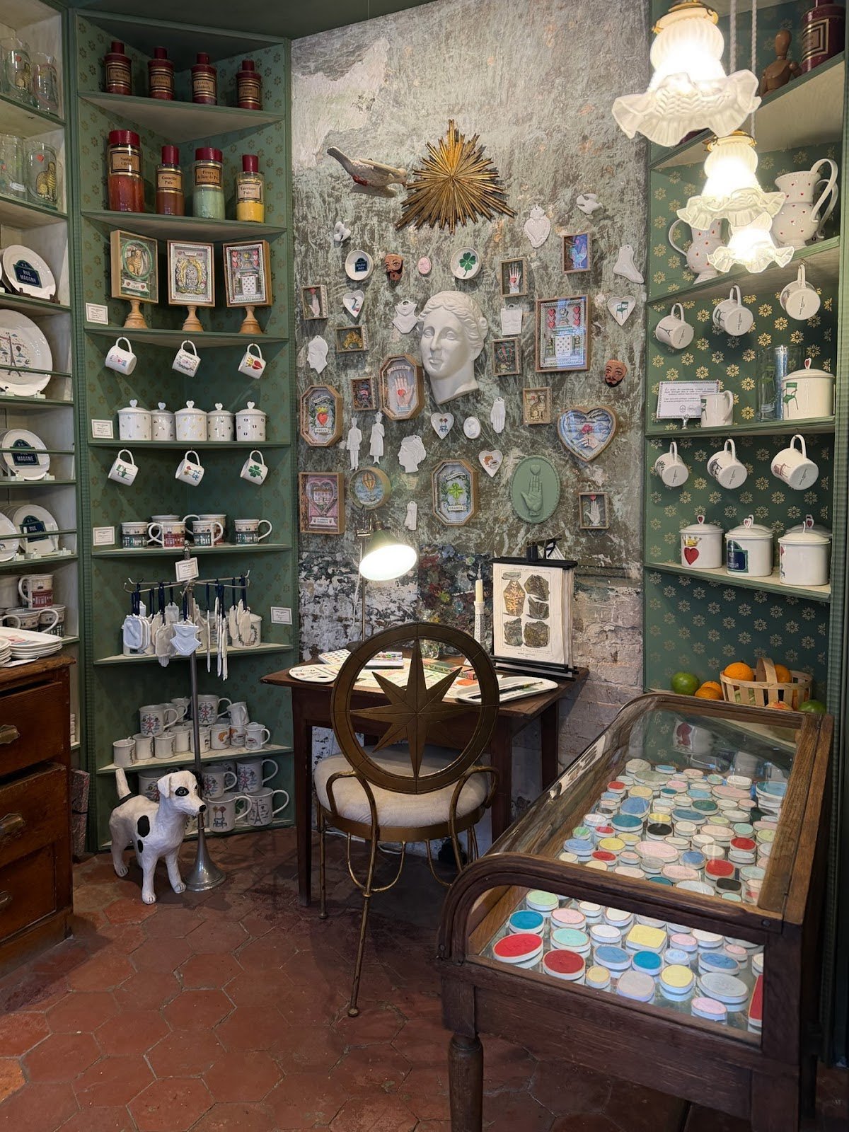 Cozy shop display with shelves of mugs, framed art, and vintage-style decor