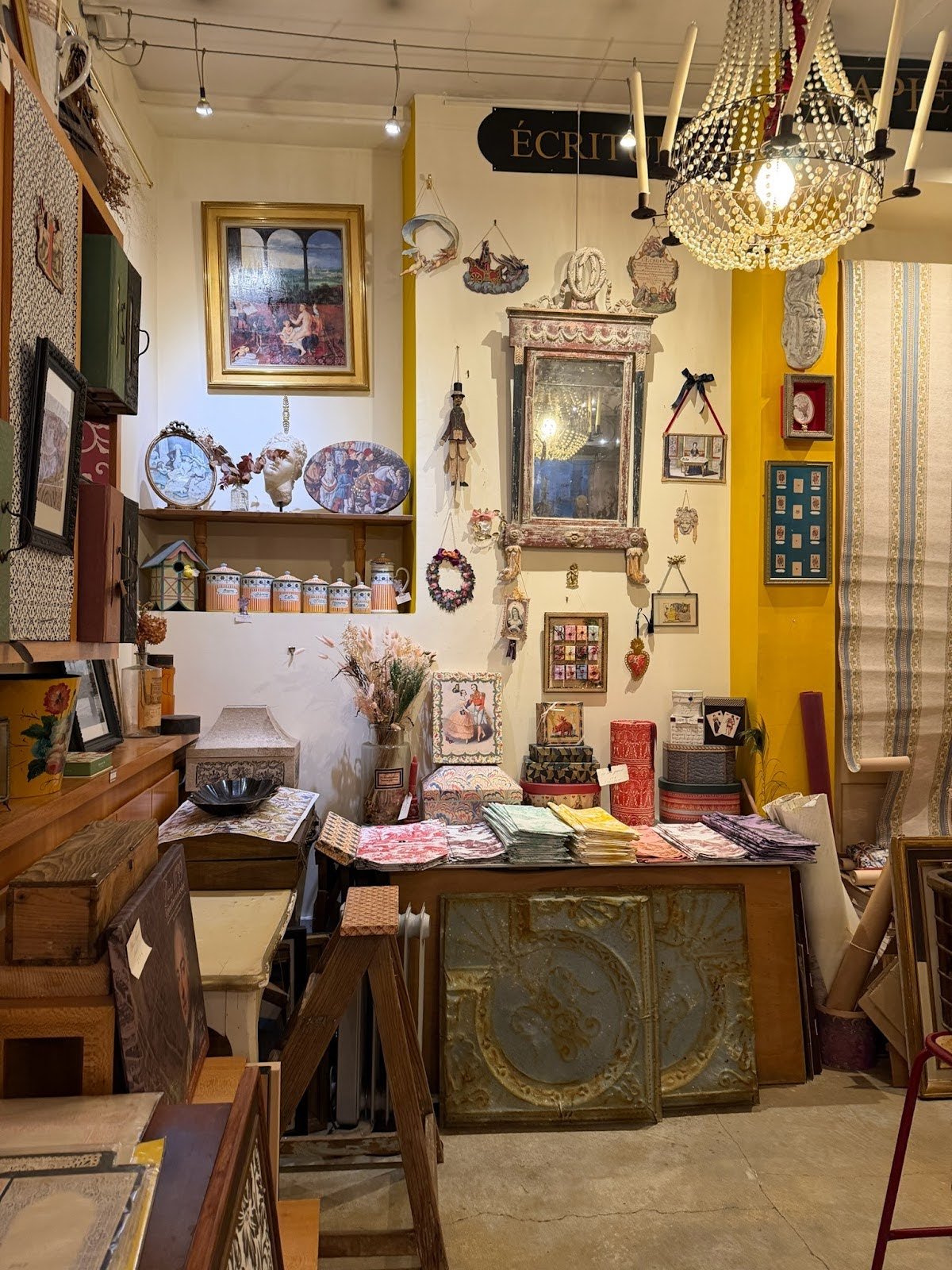  Vintage-inspired shop display with framed art, textiles, and decorative home accents